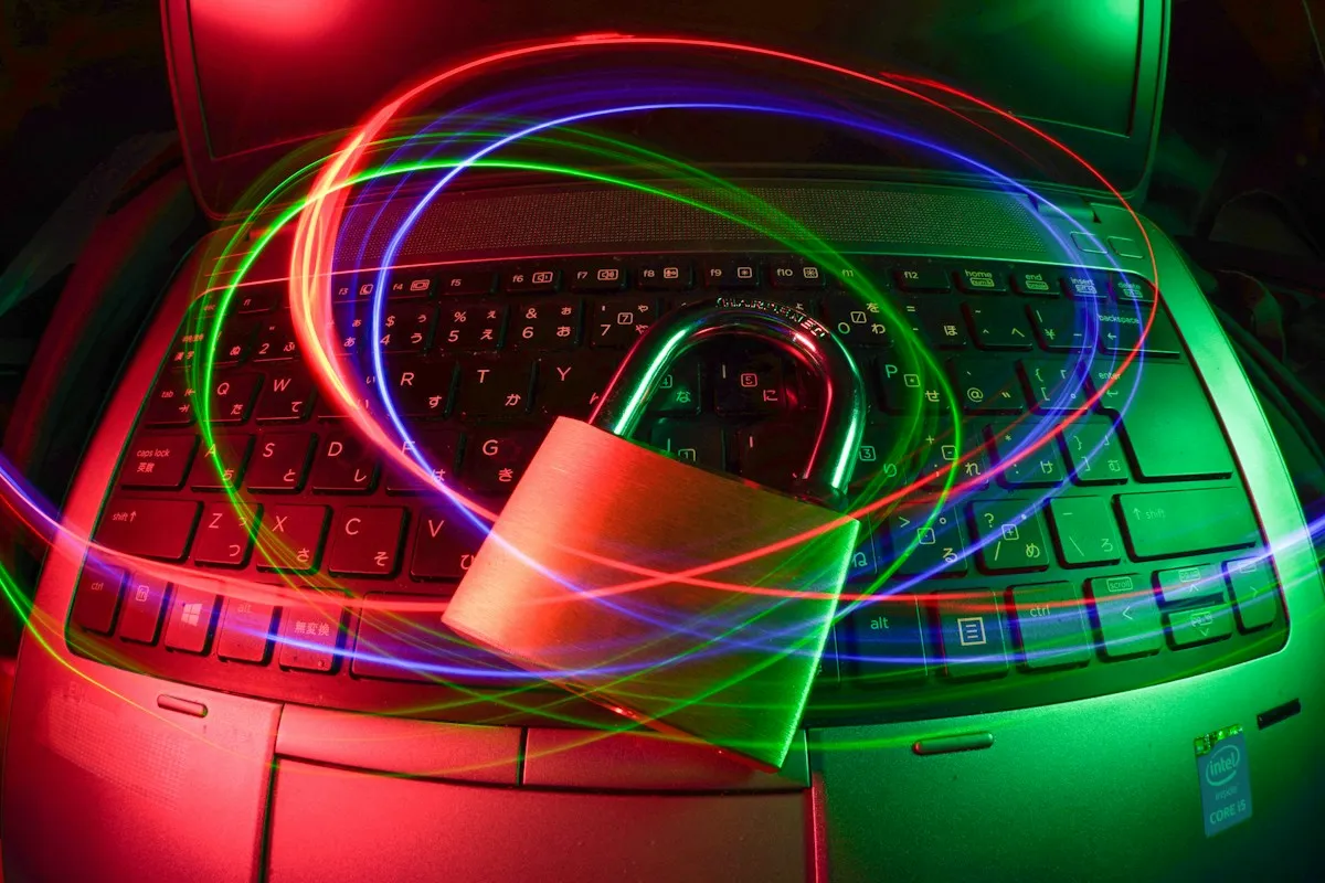 Padlock on a laptop keyboard with coloured light trails
