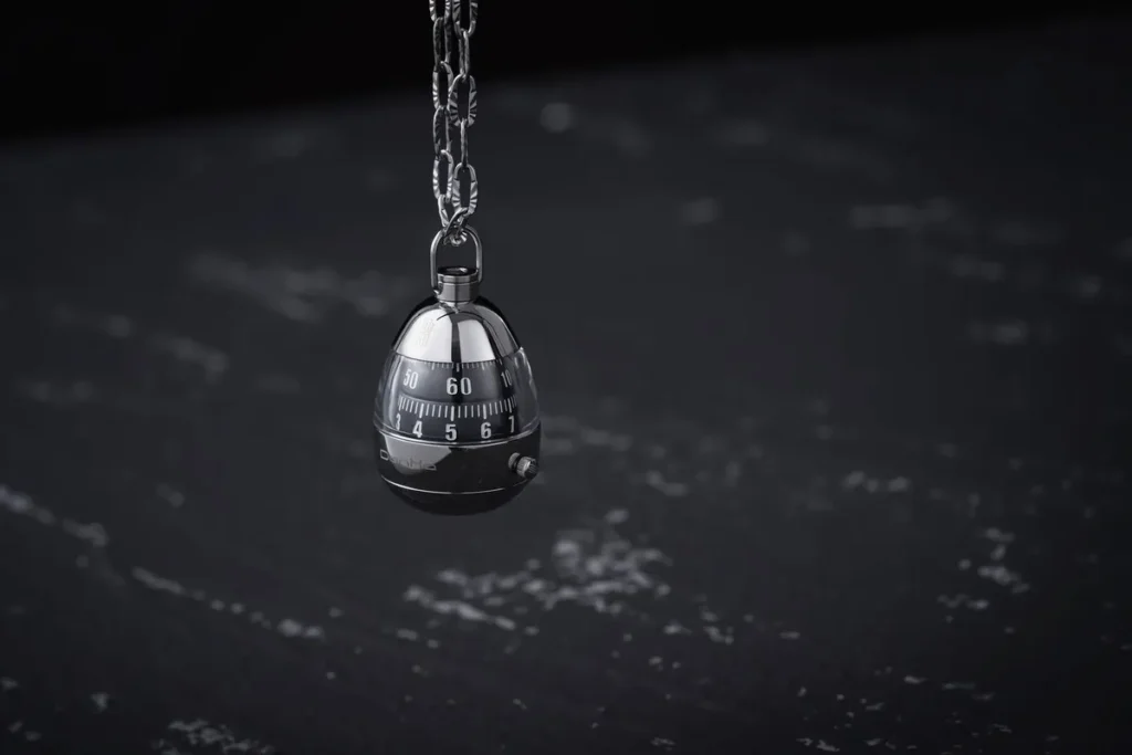 Combination lock hanging on a metal chain against a dark background